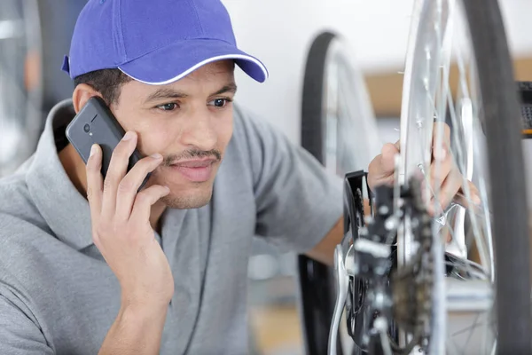 serviceman on the phone adjusting bicycle