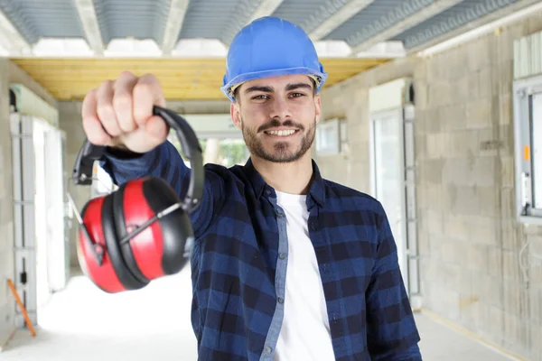young worker with noise cancelling headphones on white