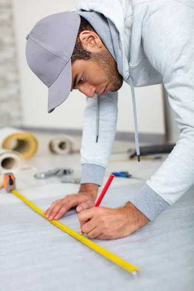 Young Man Holds Level Measuring Floor — Stock Photo, Image