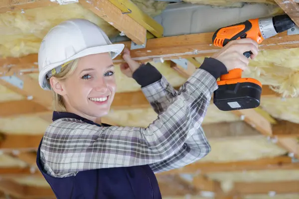 建設現場の女性大工掘削木製屋根 — ストック写真
