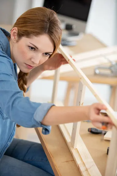 woman putting together self assembly furniture