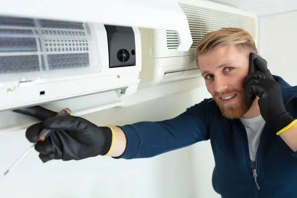 Glücklicher Männlicher Techniker Repariert Klimaanlage Mit Schraubenzieher — Stockfoto