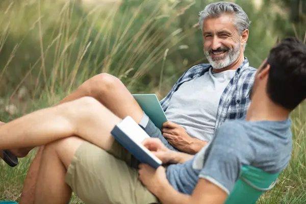 本を読んでいるキャンプの椅子の男性 — ストック写真