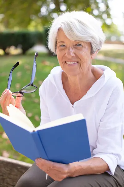 Senior Woman Reading Book Laid Grass — Stock Photo, Image