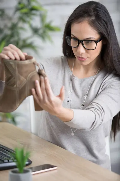 woman examining footwear for listing on website