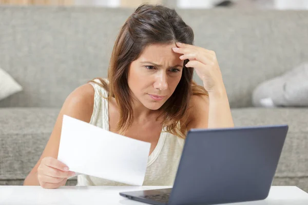 worried woman reading a letter at home