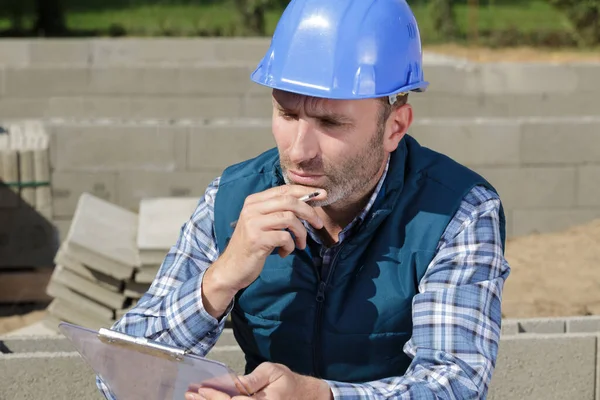 Male Builder Smoking Cigarette While Checking Clipboard — Stock Photo, Image