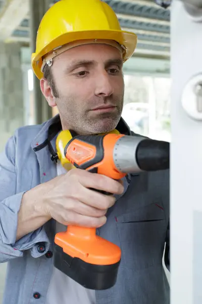 close-up of worker using power drill