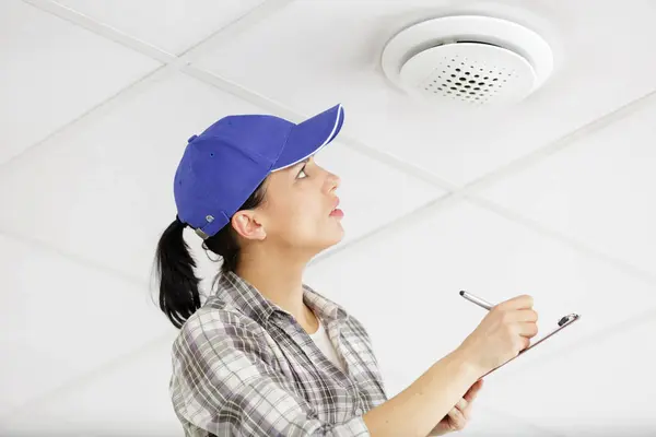 Female Worker Installing Smoke Detector Home — Stock Photo, Image