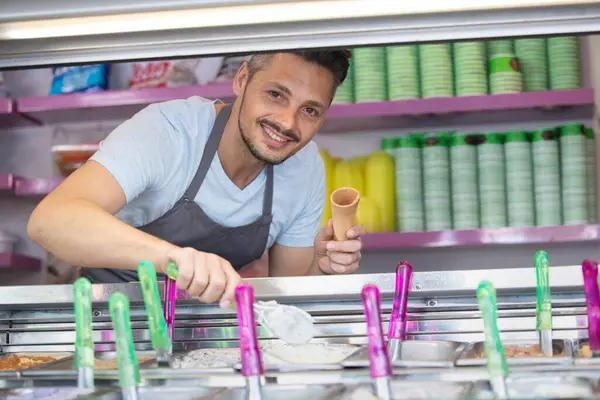 菓子店でアイスクリームを提供する男 — ストック写真