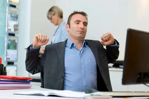 portrait of businessman stretching in office