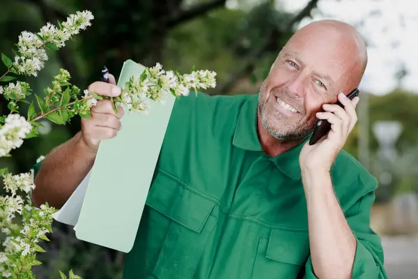 Elinde Dosya Tutan Telefon Kullanan Yaşlı Bir Bahçıvan — Stok fotoğraf