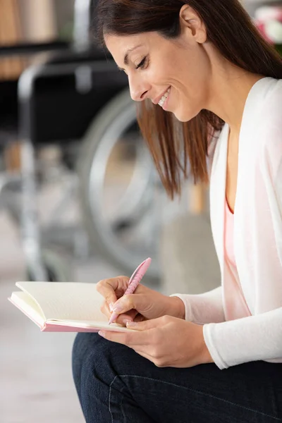 disabled woman in wheelchair writing