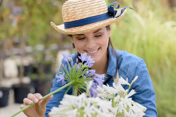 Woman Wearing Straw Hat Arranges Cut Flowers Outdoors — Stock Photo, Image