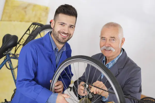 Dois Homens Consertando Uma Bicicleta Juntos — Fotografia de Stock