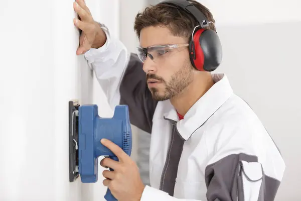 Concentrated Male Builder Sanding Wall — Stock Photo, Image