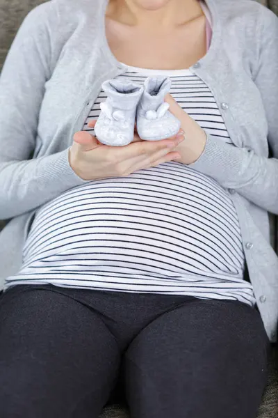 Mooie Zwangere Vrouw Met Baby Laarzen Kleur Achtergrond — Stockfoto