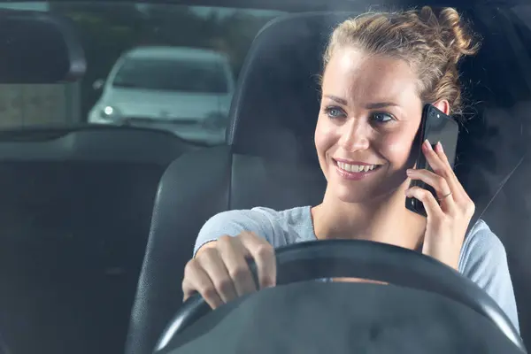 車を運転しながら電話で幸せな女性 — ストック写真