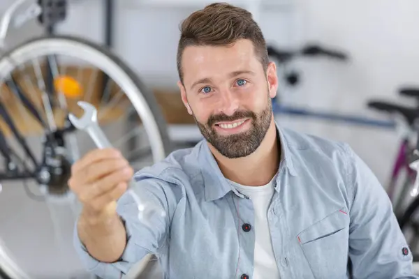 Man Showing Spanner While Fixing Bicycle Wheel — Stock Photo, Image