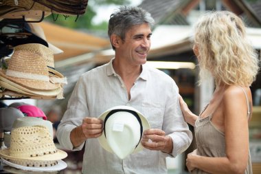 mature couple are enjoying shopping hats clipart