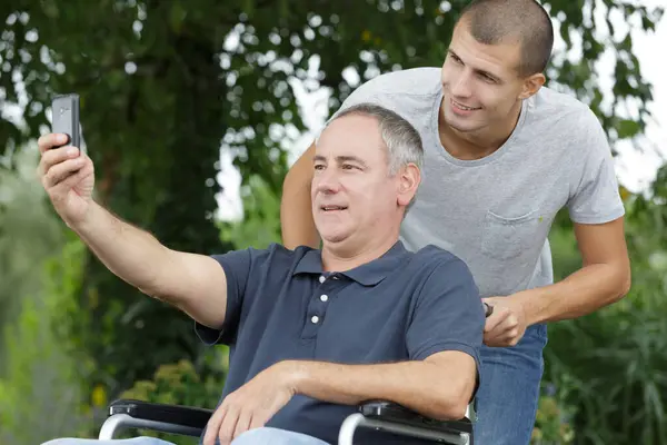 Tekerlekli Sandalyedeki Özürlü Baba Oğluyla Selfie Çekiyor — Stok fotoğraf