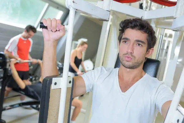 Jonge Man Training Borstspieren Fitnessapparaat — Stockfoto