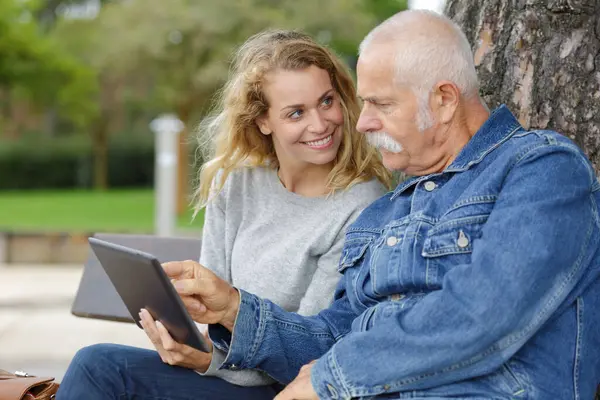 Senior Man Dochter Met Behulp Van Tablet Buiten — Stockfoto