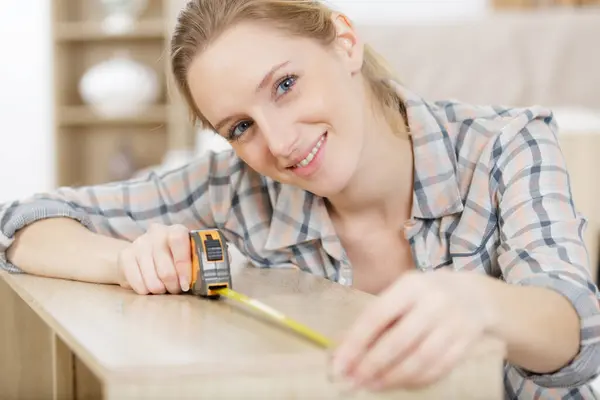 Happy Woman Measures Wooden Board — Stock Photo, Image