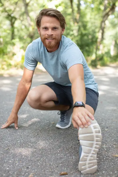 Männlicher Läufer Wärmt Sich Mit Beinstreckung Auf — Stockfoto