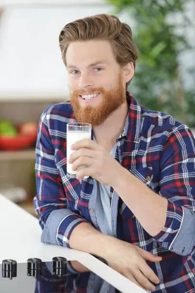 一个笑着喝牛奶的男人 图库图片