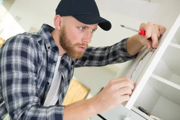Handyman Installing Kitchen Cupboard — Stock Photo, Image