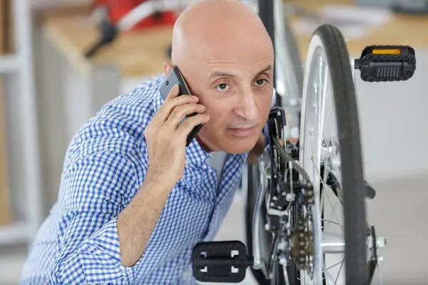 携帯電話の小さな自転車のビジネスオーナー ストック写真