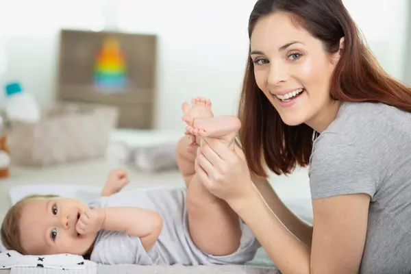 Mãe Colocando Fralda Seu Bebê Feliz Berçário — Fotografia de Stock