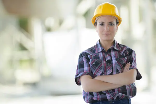 建設現場で働く女性が腕を横切りました ストック写真
