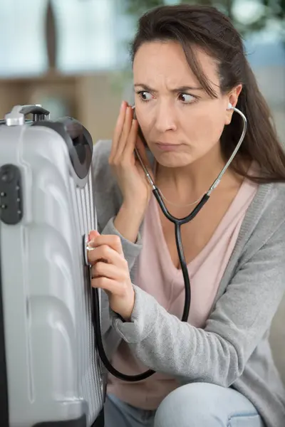 Bewildered Woman Holding Stethoscope Her Suitcase — Stock Photo, Image