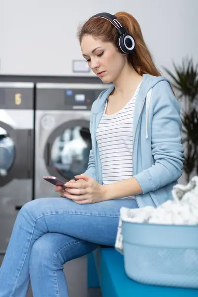 Kvinna Tvättomat Med Smartphone Och Hörlurar — Stockfoto