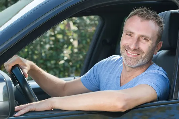 handsome male driver smiling to the camera