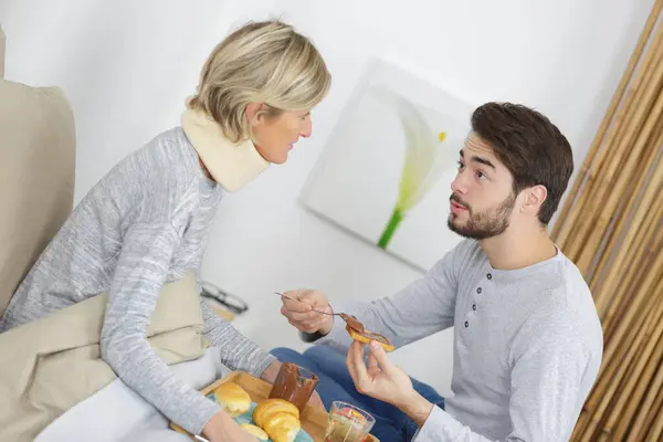 Young Man Serving Food Injured Woman Bed — Stock Photo, Image