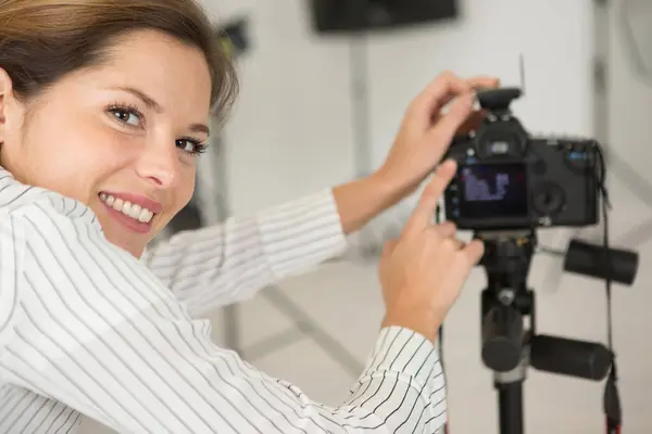 快乐的女摄影师站在工作室的肖像 图库图片
