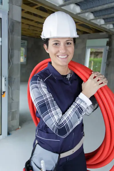 Female Builder Carrying Red Pipe Her Shoulder — Stock Photo, Image