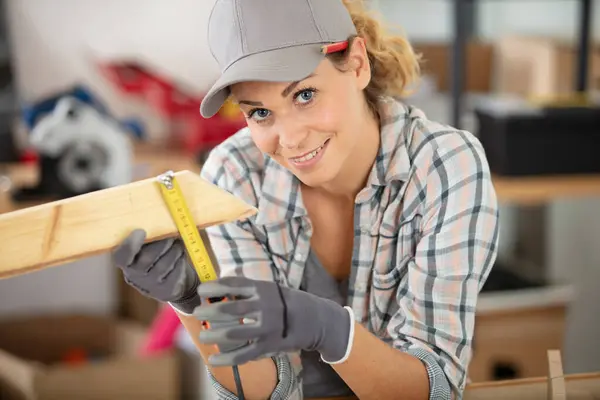 木片の測定値を示す女性大工 — ストック写真