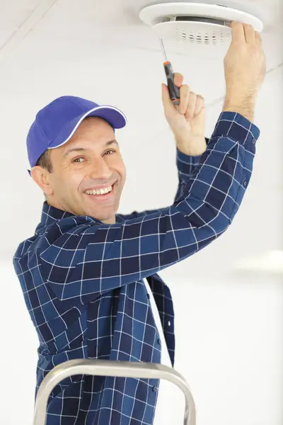 Mature Man Fitting Ceiling Vent Stock Image