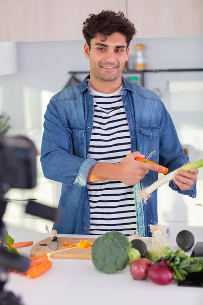 Mann Bei Der Aufzeichnung Eines Kochblogs Der Gemüse Zubereitet lizenzfreie Stockbilder