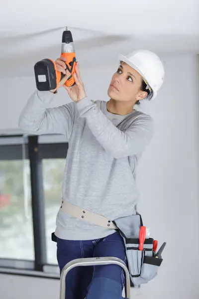 若い女性が天井を掘削し ストック写真