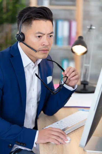 アジア系のビジネスマンがオフィスのノートパソコンで — ストック写真