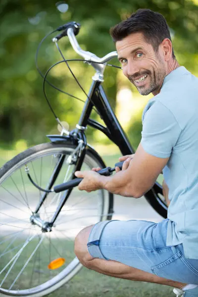 a man pumps bicycle wheel