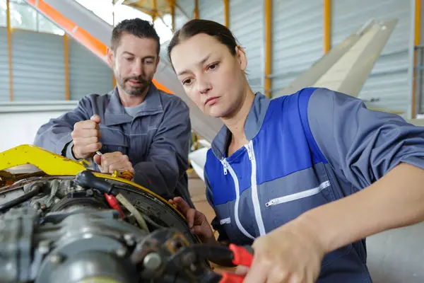 female mechanic using wrench to undo bolt on aircraft component