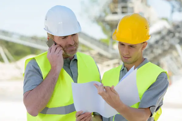 two men looking at plans on site