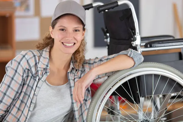 車椅子を維持する美しい女性のトレードマン ストックフォト