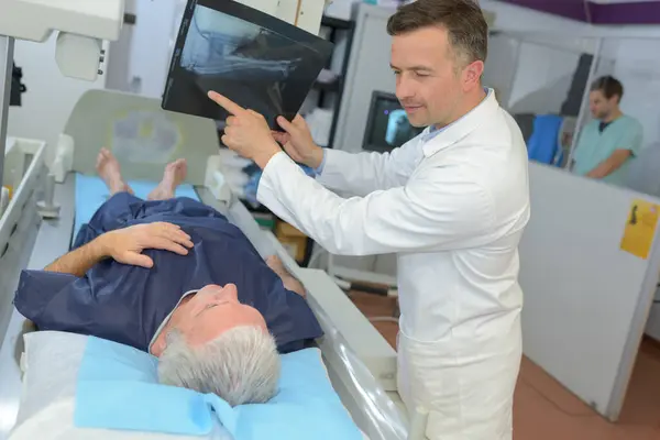 医生在医院给一位老年病人做X光检查 免版税图库照片